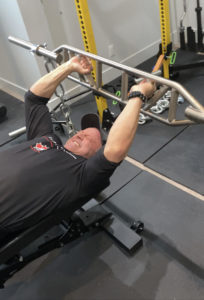 Photo of Bryan using chains, attached to the bar